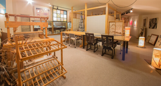 写真：ショールーム全体の様子。木製の古い道具や和紙を使った照明、障子などが展示されている